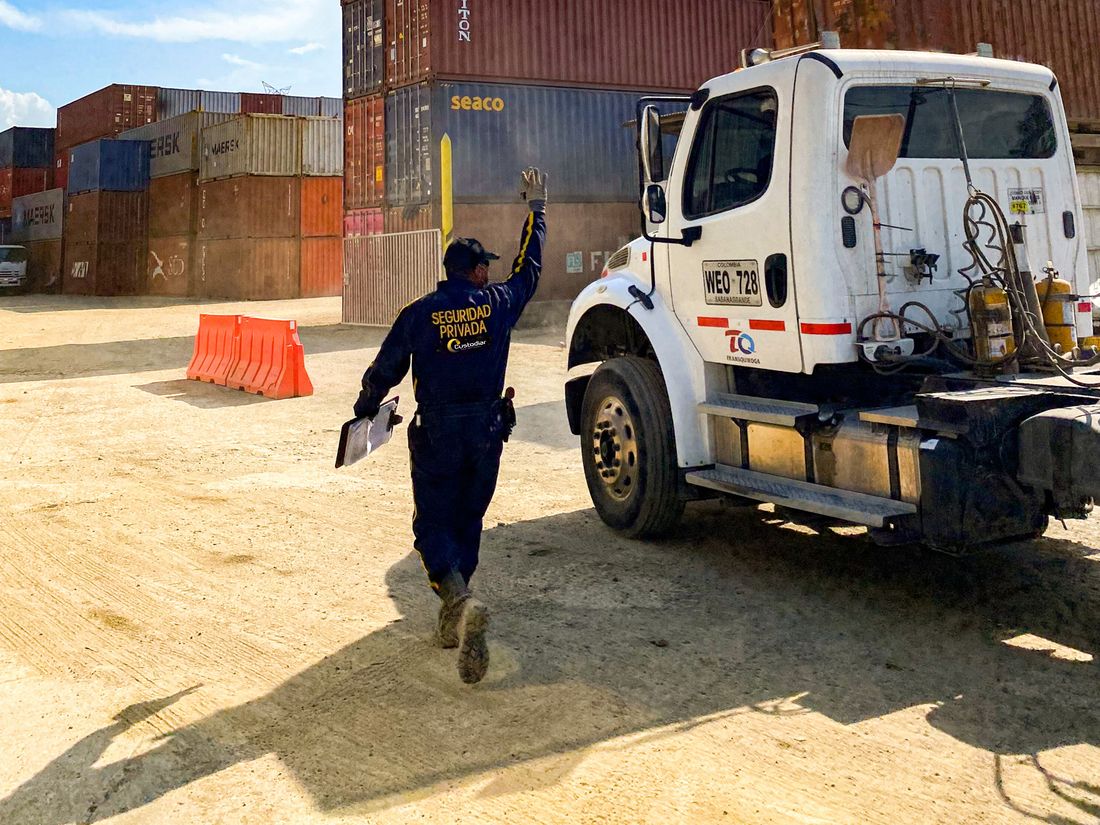 Guarda de Custodiar coordinando el ingreso de un camión en un patio de contenedores